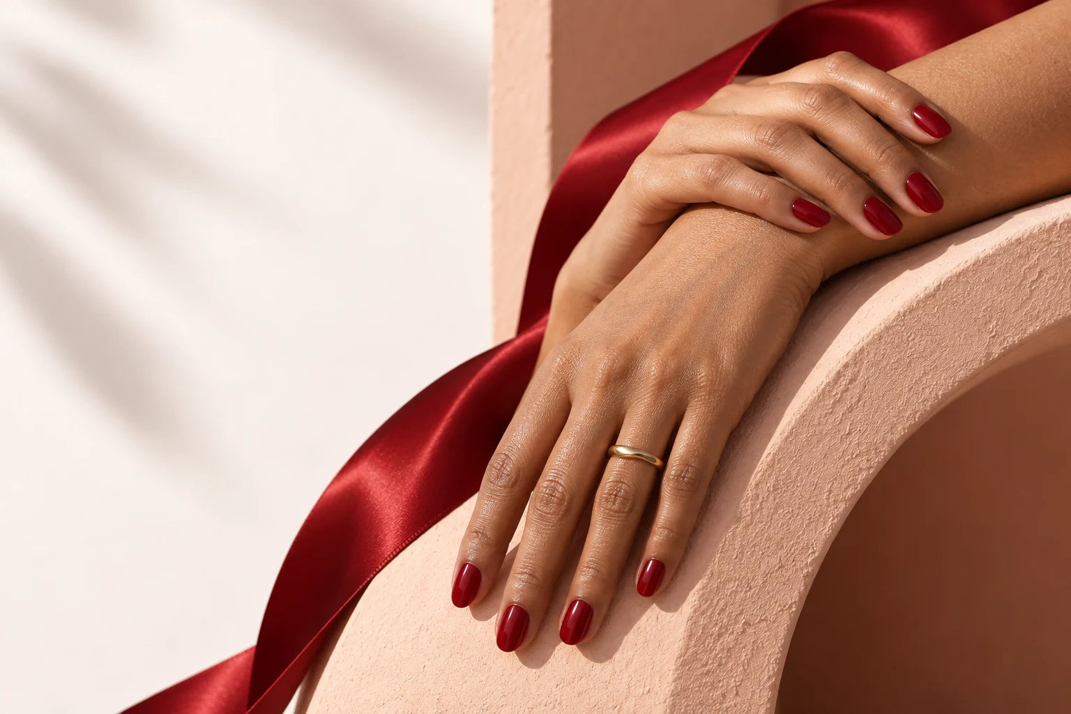Wine-red nails with warm apricot curves and red satin